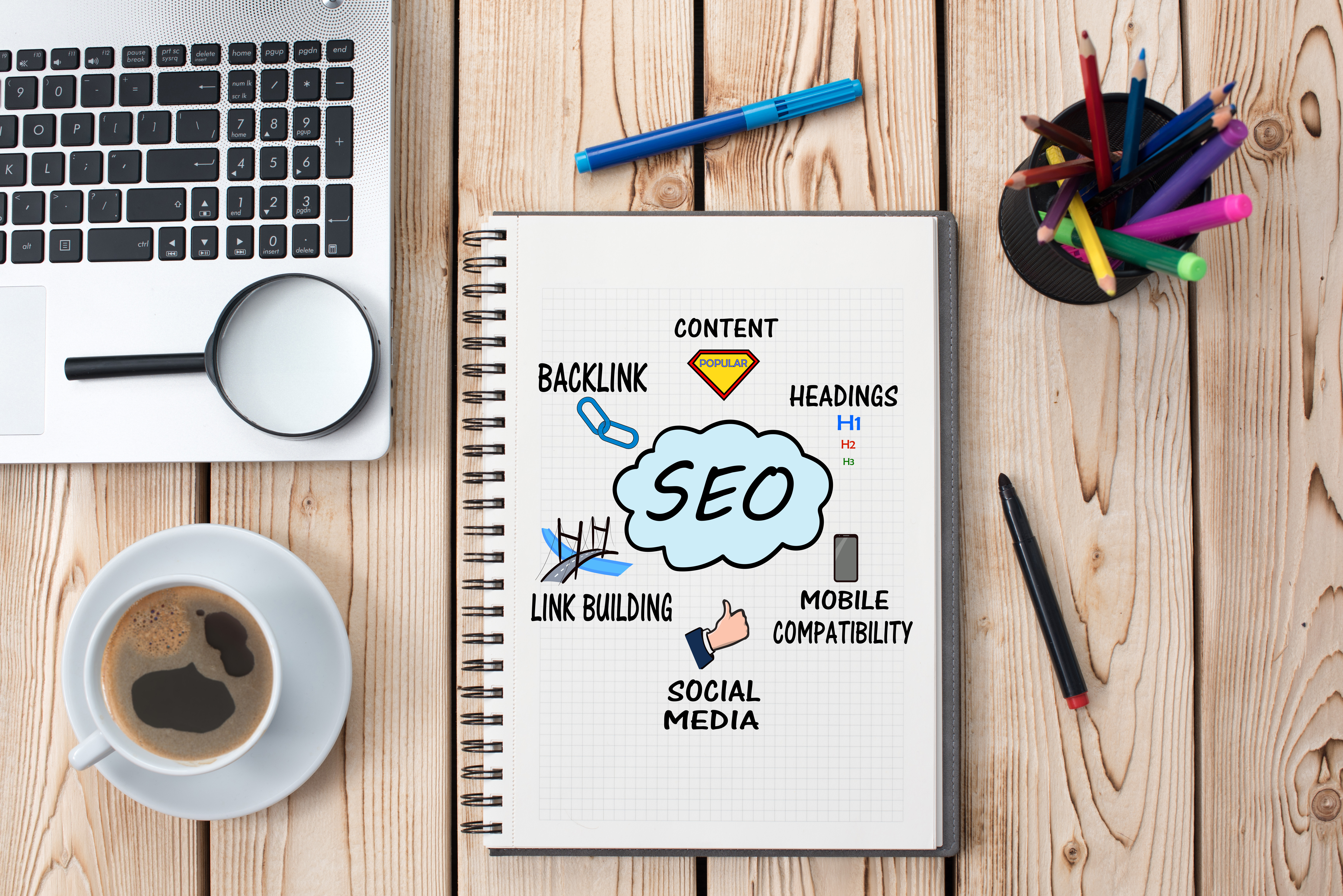 A desk and notepad with illustrations of considerations in Search Engine Optimization